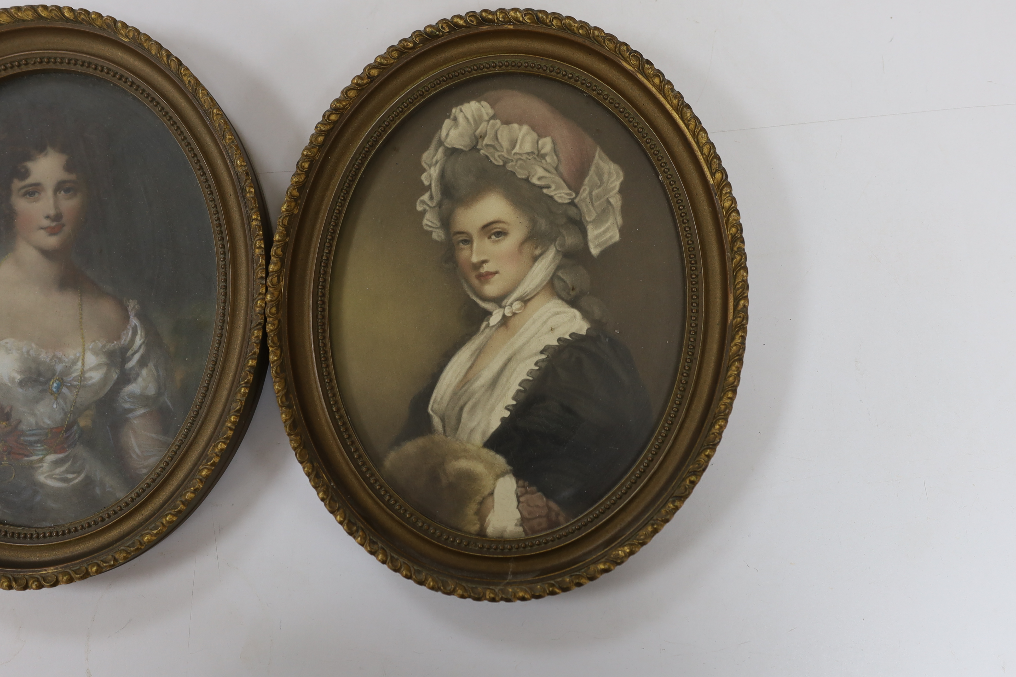 A pair of oval overpainted prints, ladies wearing Georgian dress, gilt framed, 22 x 16cm